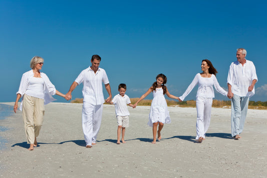 A very happy family romping on the beach holding hands
